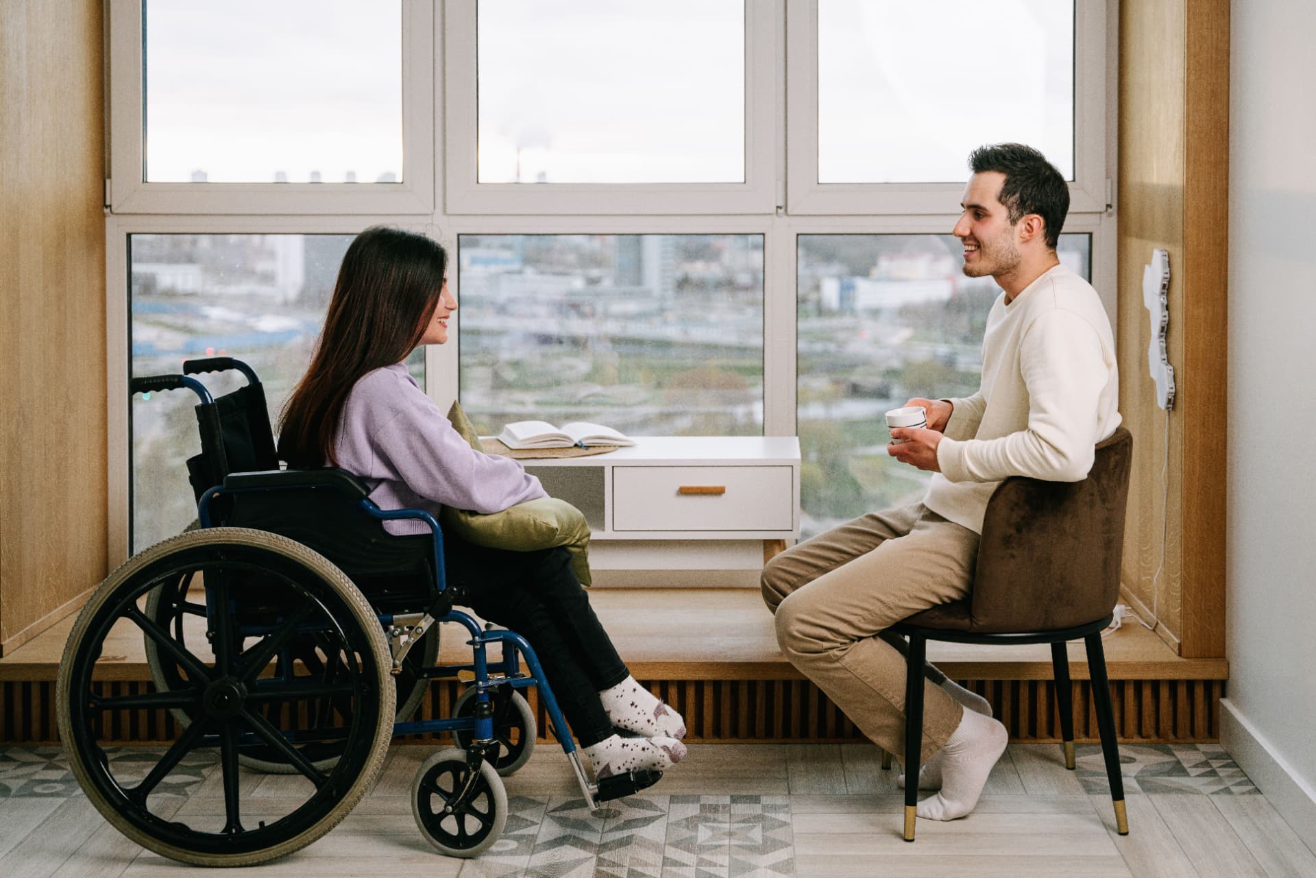 NDIS support worker speaking with a client in a bright, modern space